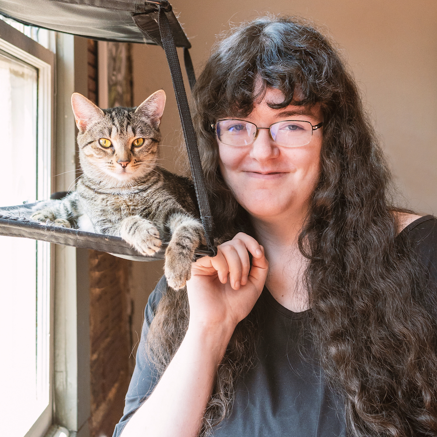 Amanda Mangiarelli standing beside a cat and smiling